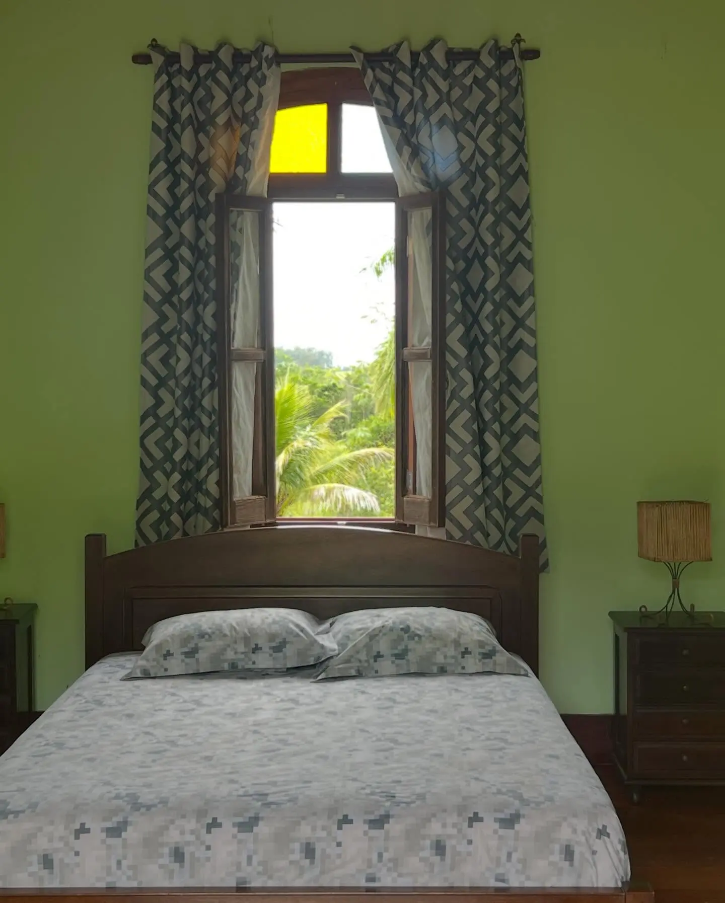 Quarto de hospedagem da Fazenda Neuchatel com janela em arco aberta para a mata